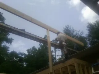 Carpenter setting a ridge beam over a new addition frame — Ice Dam Removal by Roofing Brothers in Westtown