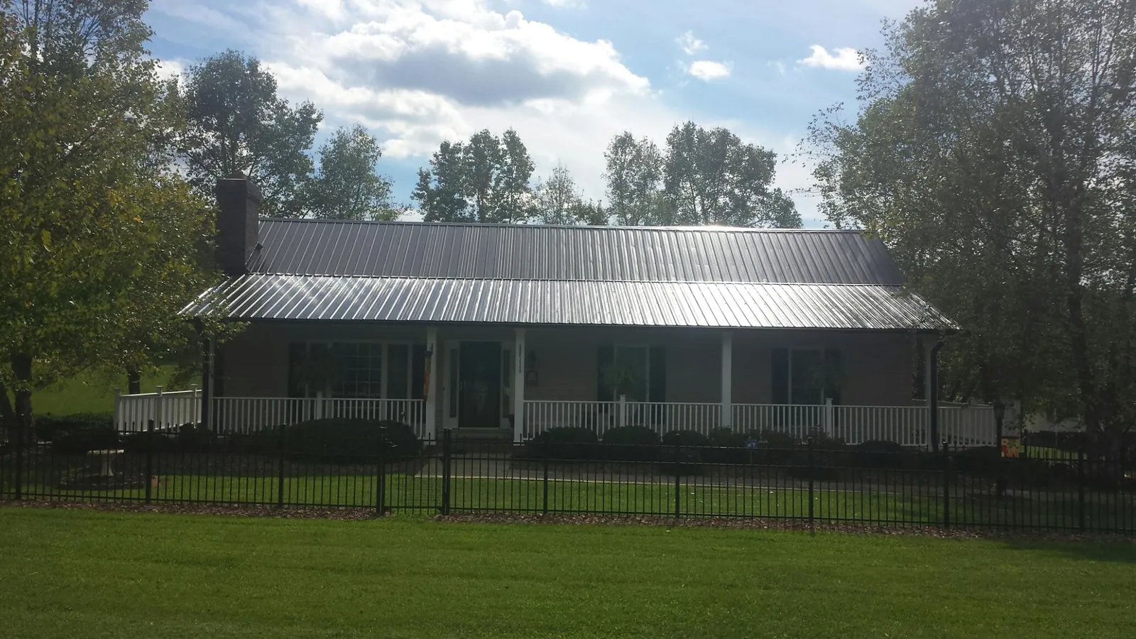 Gray metal roof on a brick ranch with a full width front porch — Gutter Guard Installation work by our crew in Westtown