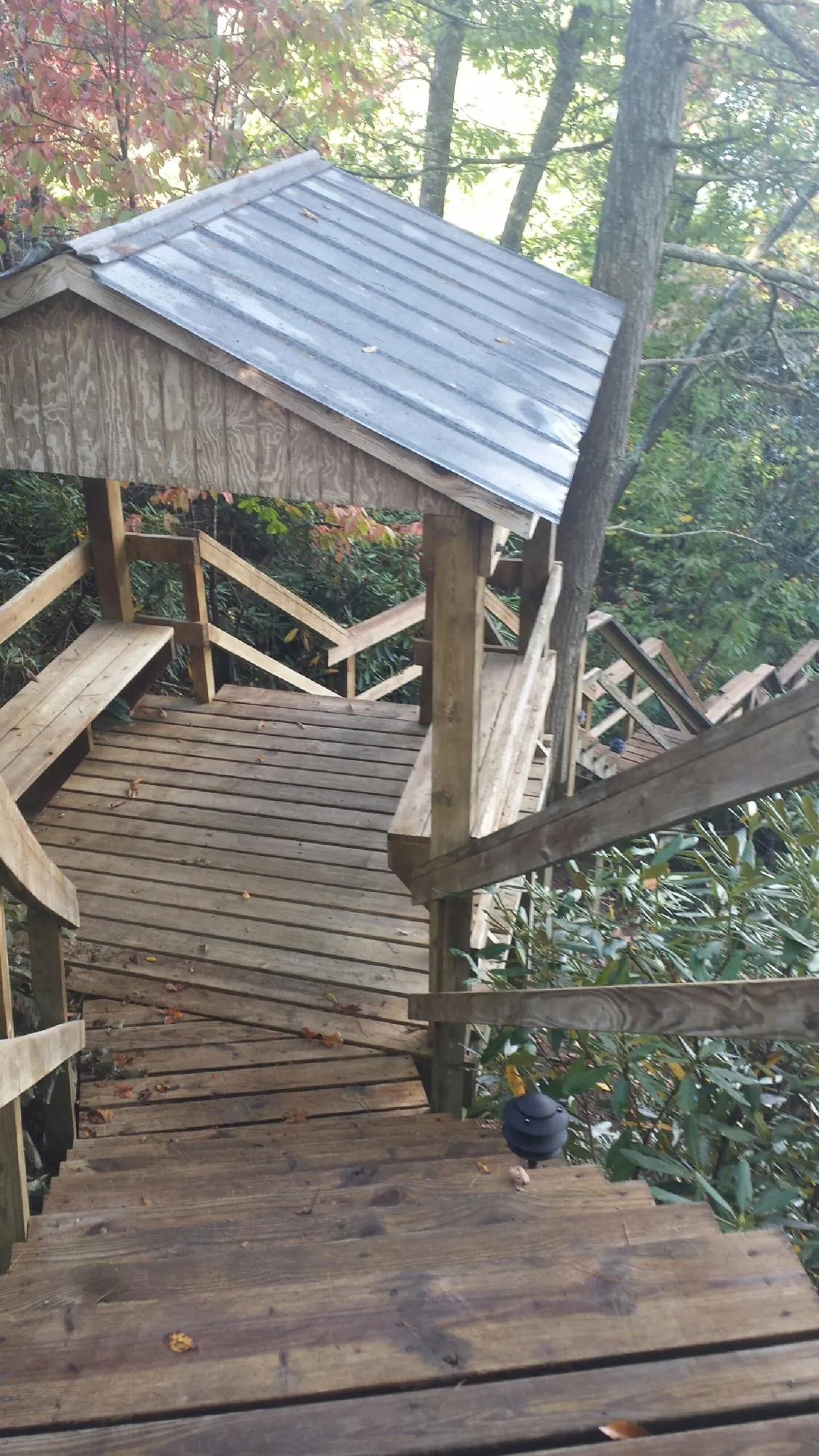 Metal roofed shelter over wooden steps on a wooded walkway — Skylight Repair & Installation work by our crew in Westtown